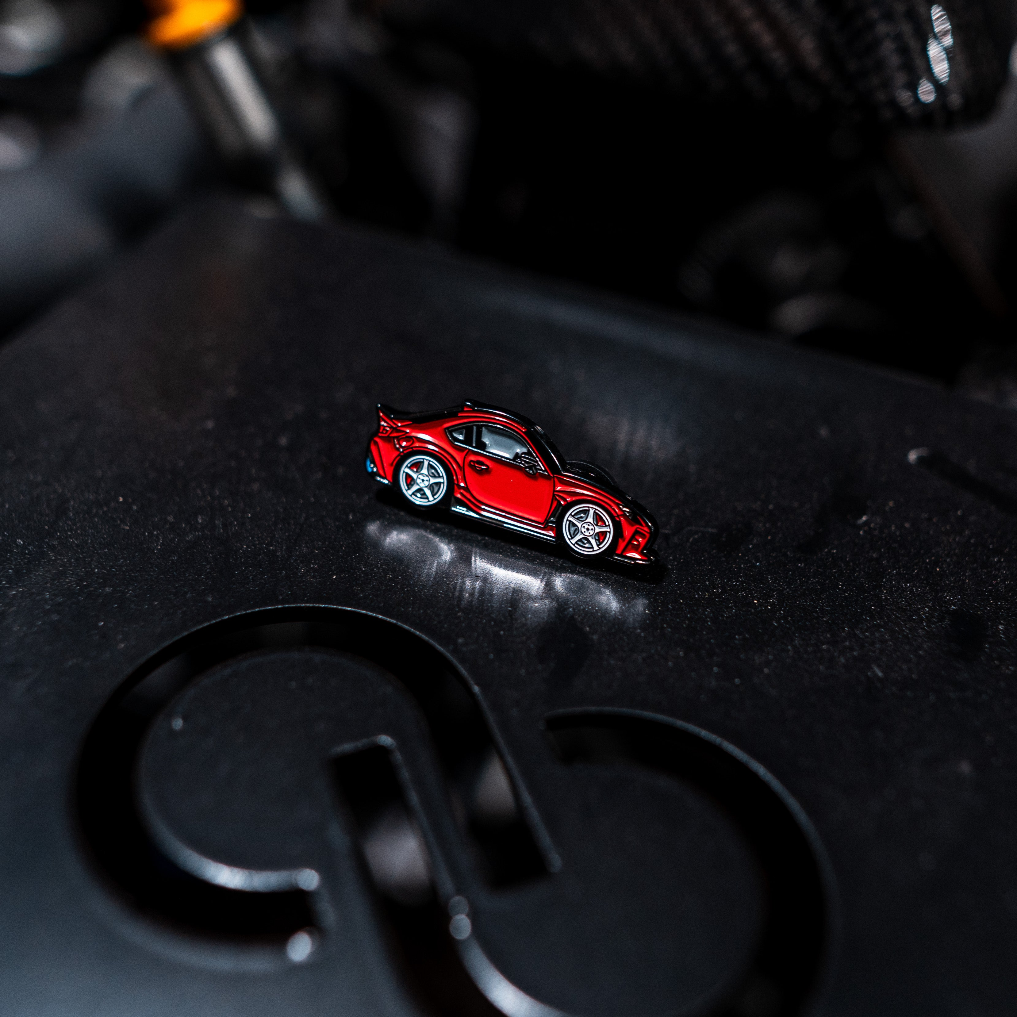 Red car model on a black surface with a blurred background
