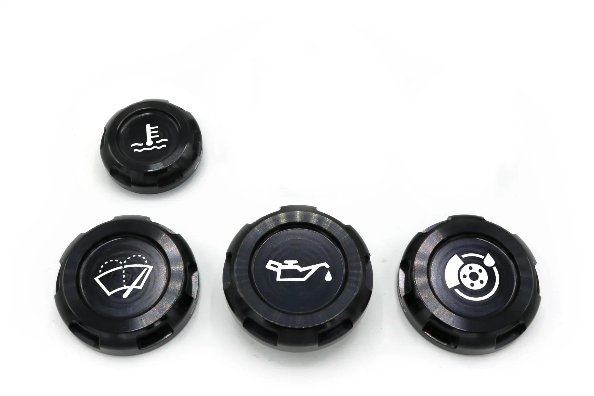A set of four black anodized aluminum engine bay caps with engravings, including oil cap, wiper fluid cap, coolant overflow cap, and brake fluid cap symbols.